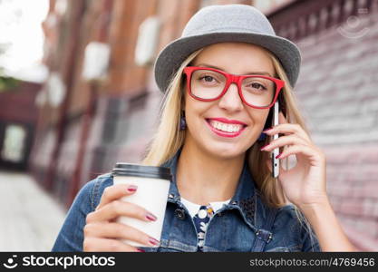 Young woman walking down the street. Young pretty girl tourist walking the street and talking on mobile phone