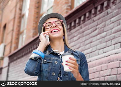 Young woman walking down the street. Young pretty girl tourist walking the street and talking on mobile phone