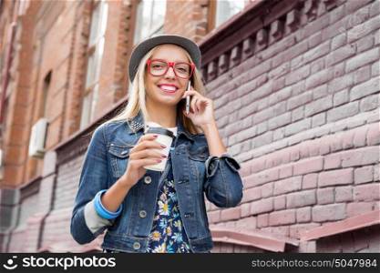 Young woman walking down the street. Young pretty girl tourist walking the street and talking on mobile phone