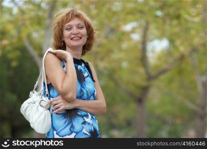 Young woman walking in autumn park soft background