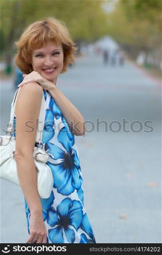 Young woman walking in autumn park soft background