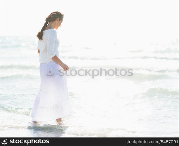 Young woman walking into sea