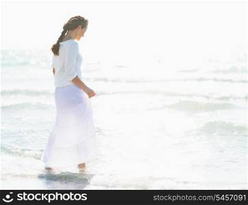Young woman walking into sea