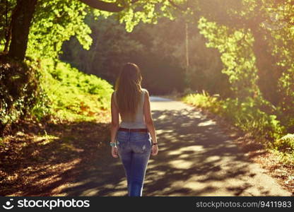 Young woman walking on a rural hiking route in summer