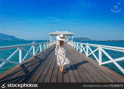 Young woman walking on wooden bridge in Si chang island, Thailand.