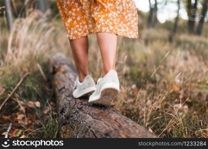 Young woman walking through the forest wearing dresses