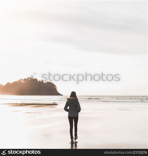 young woman walking towards sea