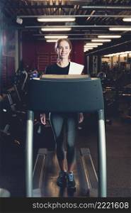 young woman walking treadmill gym