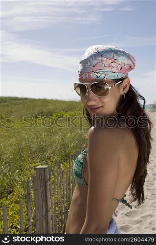 Young woman walking up path on beach