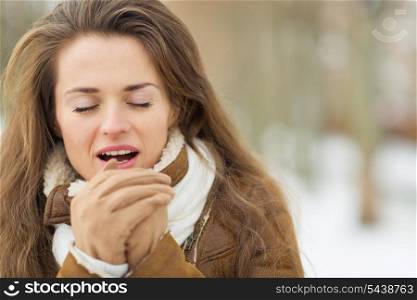 Young woman warming hands in winter outdoors
