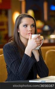 young woman warming herself with e hot cup of tea between hands