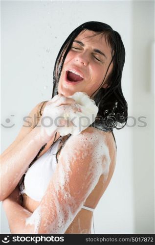 Young woman washing body with shower gel at home or hotel