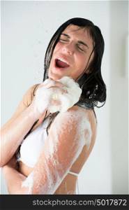 Young woman washing body with shower gel at home or hotel