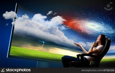 Young woman watching 3d tv. Image of young woman in armchair watching 3d tv
