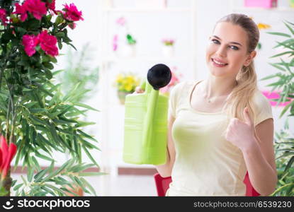 Young woman watering plants in her garden