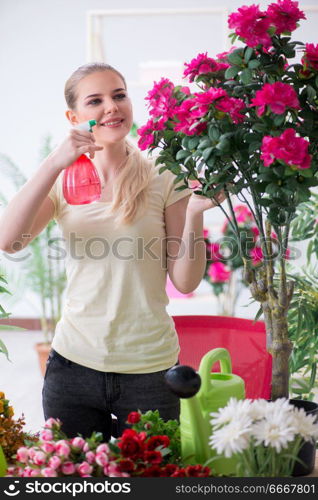 Young woman watering plants in her garden