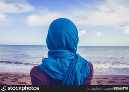 Young woman wearing a headscarf on the beach
