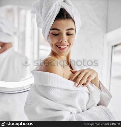young woman wearing bathrobe towel her hair