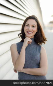 Young woman wearing casual clothes smiling in urban background. Girl with beautiful smile