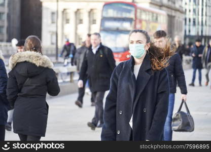 Young woman wearing face mask while walking in the streets of London