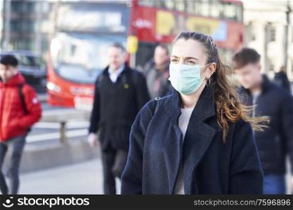 Young woman wearing face mask while walking in the streets of London