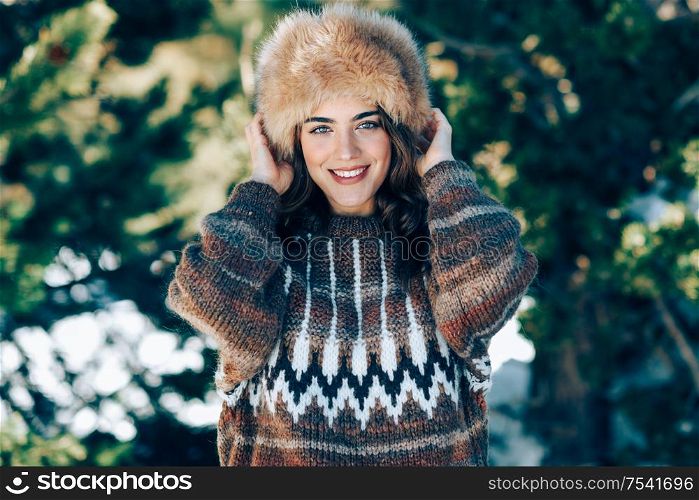 Young woman wearing fur hat enjoying the snowy mountains in winter, in Sierra Nevada, Granada, Spain. Female wearing winter clothes.. Young woman enjoying the snowy mountains in winter