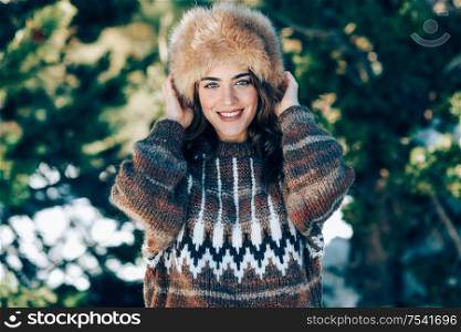 Young woman wearing fur hat enjoying the snowy mountains in winter, in Sierra Nevada, Granada, Spain. Female wearing winter clothes.. Young woman enjoying the snowy mountains in winter