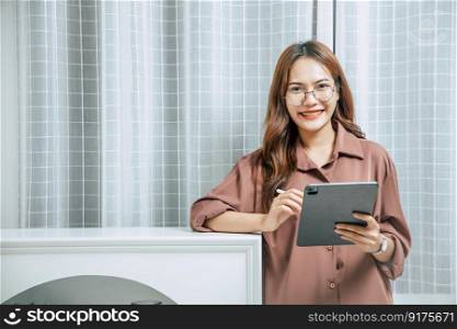 Young woman wearing glasses using technology of digital pen on tablet to working from home during self-isolation and quarantine covid-19 coronavirus outbreak