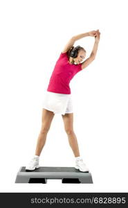 Young woman wearing headphones stretches to the top on a fitness stand over white background