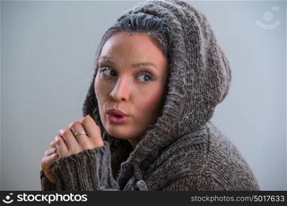 Young woman wearing hoodie warming after cooling in snow. Frost makeup
