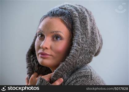 Young woman wearing hoodie warming after cooling in snow. Frost makeup