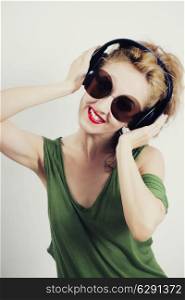 Young woman wearing sunglasses and wireless headphones
