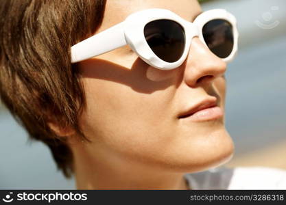 Young Woman Wearing Sunglasses, selective focus on nearest part