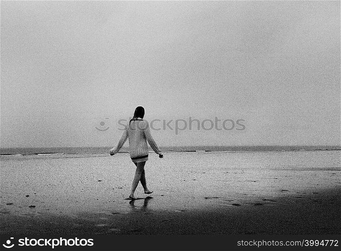 Young woman wearing sweater walking on beach