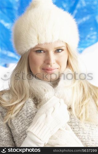 Young Woman Wearing Warm Winter Clothes And Fur Hat In Studio