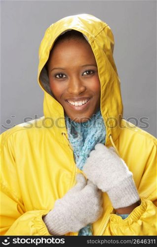 Young Woman Wearing Yellow Raincoat In Studio