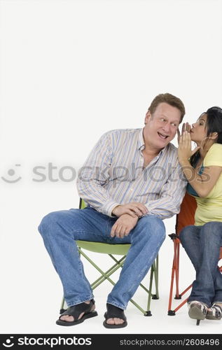 Young woman whispering in her father&acute;s ear