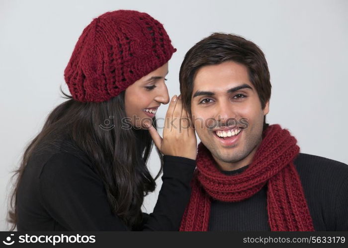Young woman whispering in man&rsquo;s ear