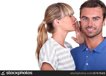 Young woman whispering into her boyfriend&acute;s ear