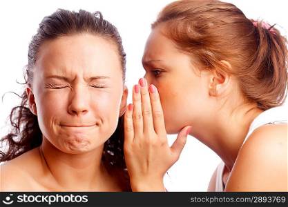 Young woman whispering something to her friend.