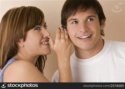 Young woman whispering to a young man