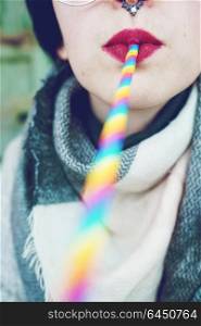Young woman who has a rainbow straw