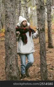 young woman winter clothes standing trees