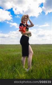 Young woman with a bouquet of tulips in the field.. Young woman with bouquet of tulips in the field.