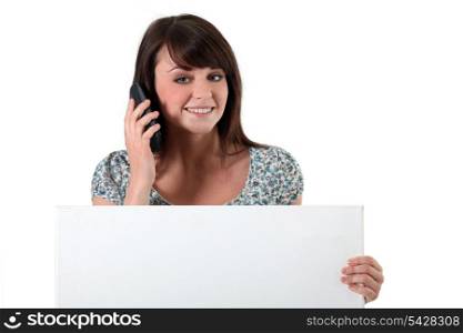 Young woman with a cellphone and a board left blank for your message