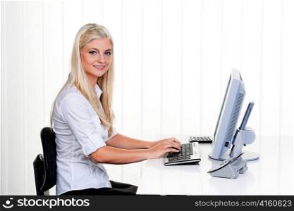 young woman with a computer at work. seated at desk