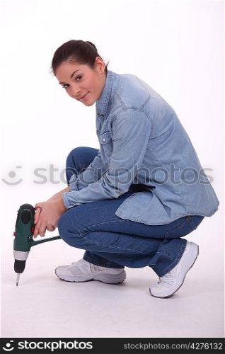 Young woman with a drill