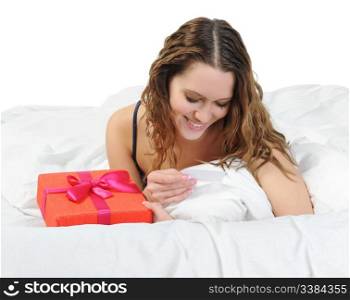 young woman with a gift box in the bed. Isolated on white background