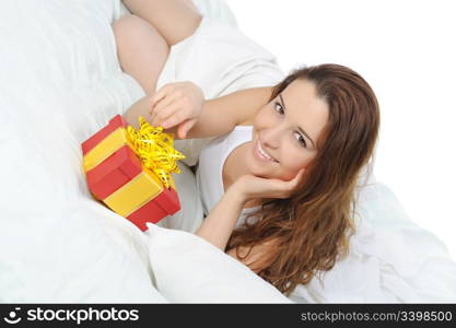 young woman with a gift box in the bed. Isolated on white background
