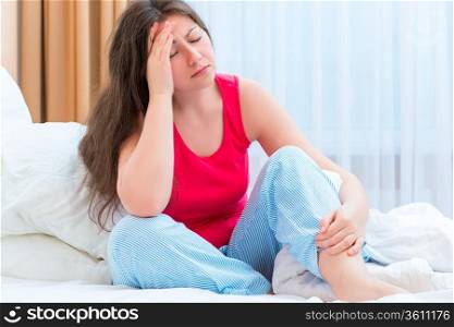 young woman with a headache in bed